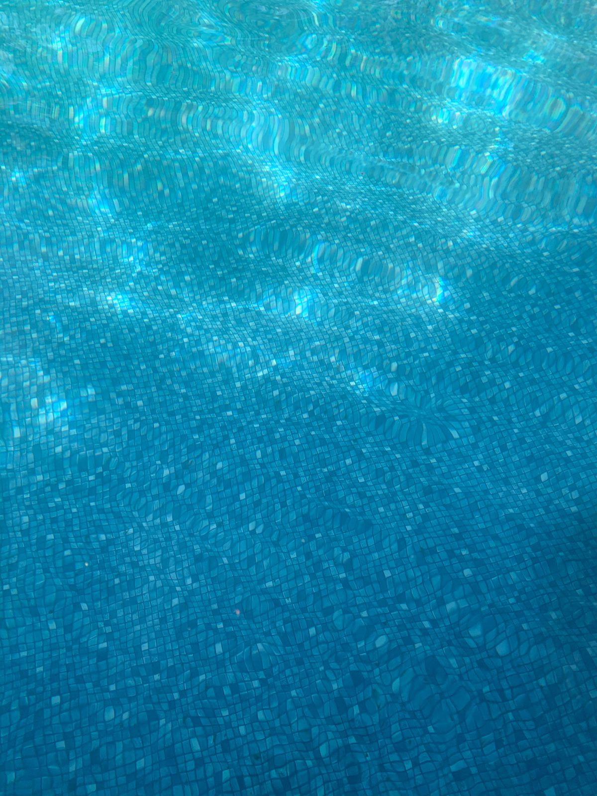 Robot limpiafondos trabajando en el fondo de una piscina